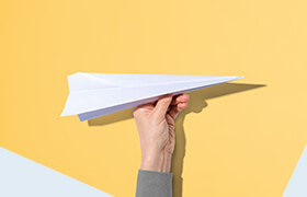 Hand mit Papierflieger