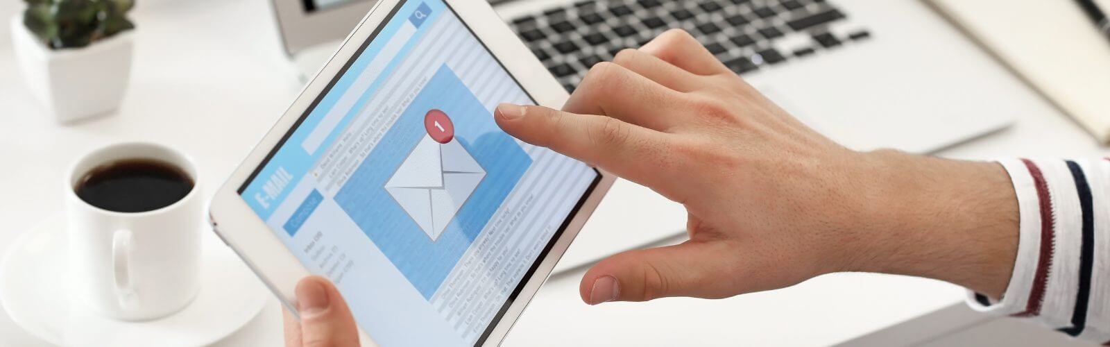 DMARC Bild: Hand tippt ein iPad, das einen Briefumschlag anzeigt.